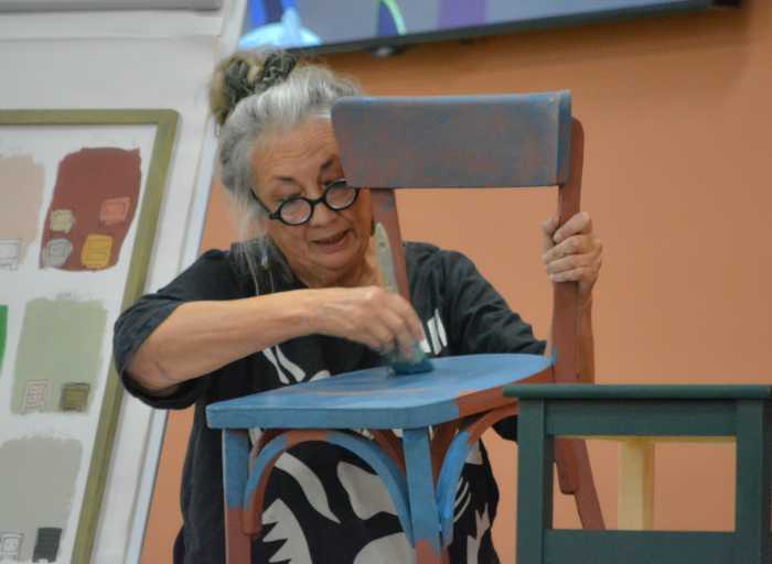 Annie Sloan painting a chair with chalk Paint